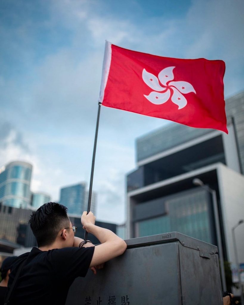 Protestor waving Hong Kong flag outside the Government Headquarters